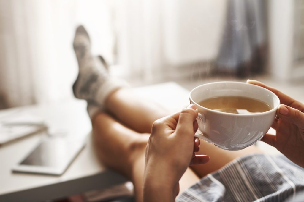Cup,Of,Tea,And,Chill.,Woman,Lying,On,Couch,,Holding