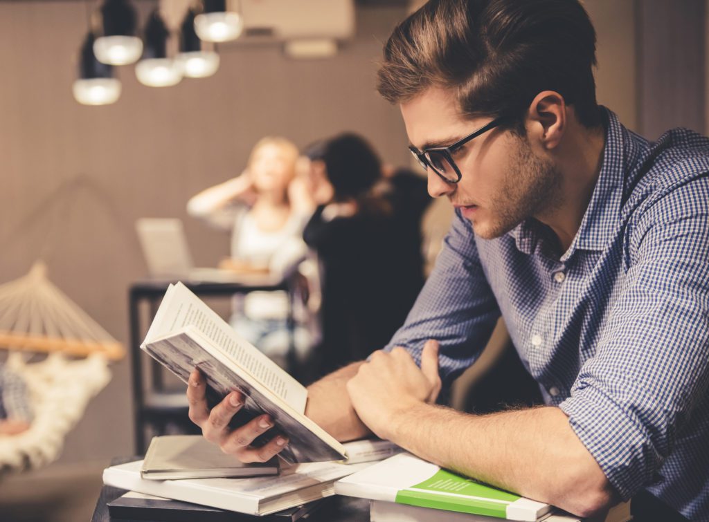 Concentrated,Young,Man,Is,Reading,A,Book,While,Working,Hard