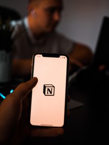 A smartphone held with the Notion app loading page on the screen