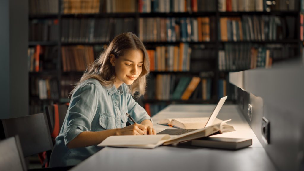 University,Library:,Beautiful,Smart,Caucasian,Girl,Uses,Laptop,,Writes,Notes