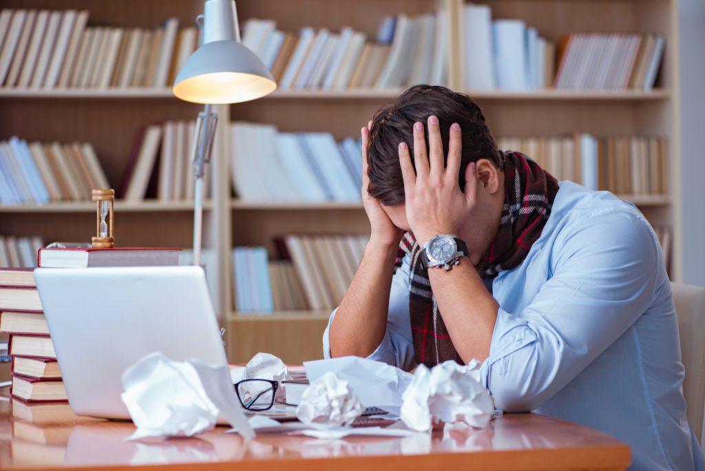 male student in a library in a slump