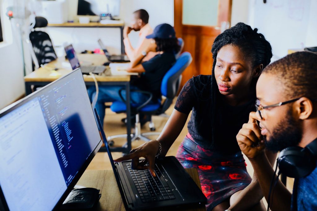 a woman assisting a student on a laptop