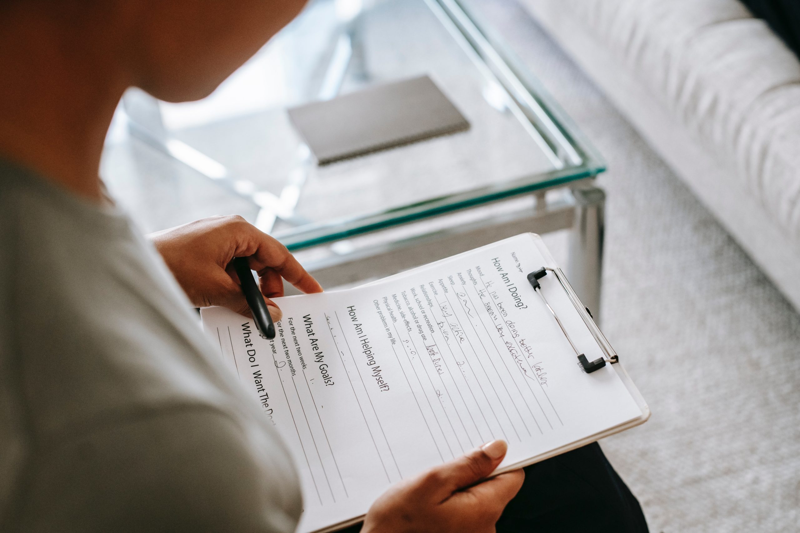 person filling out application form on a clipboard