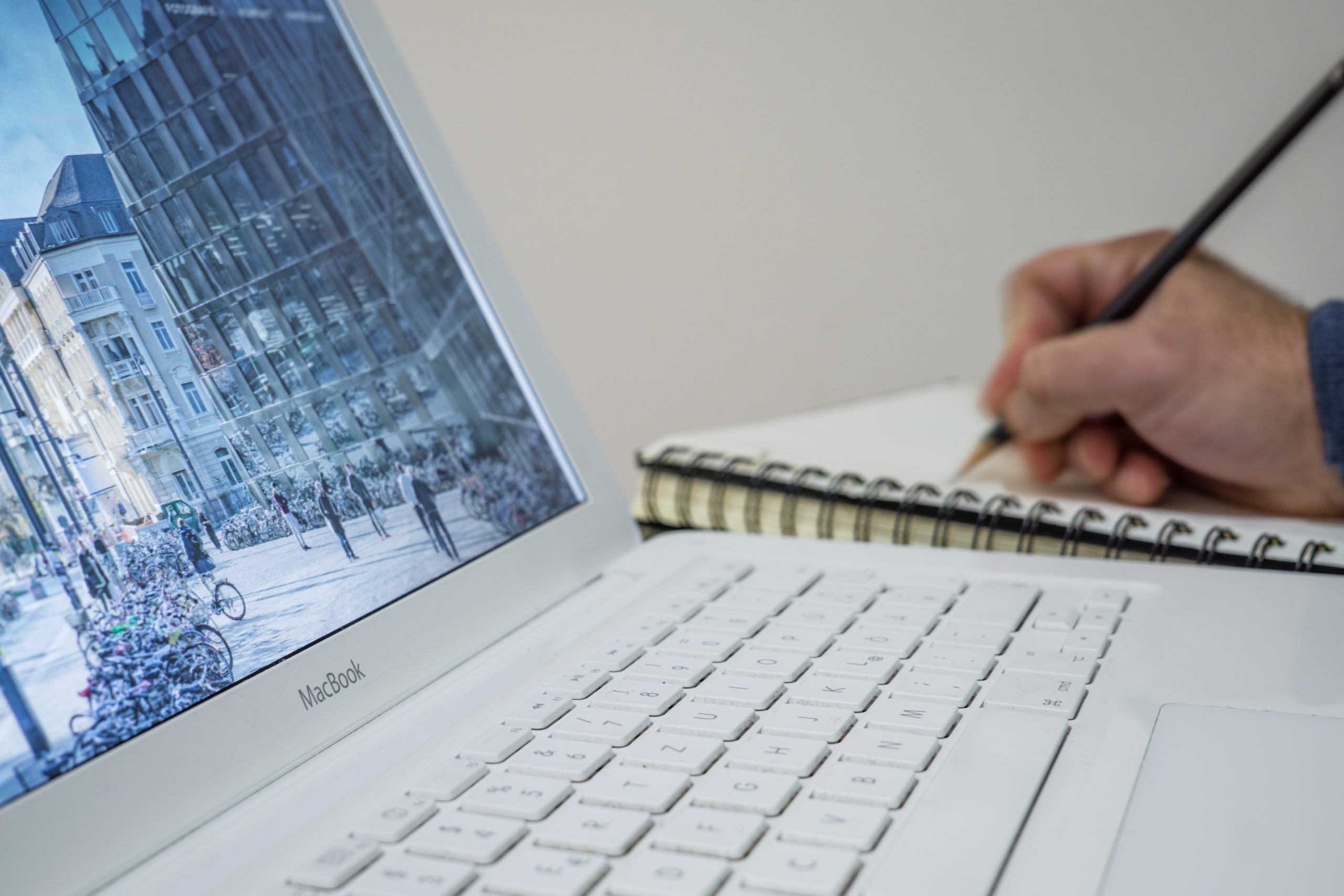 open laptop and notebook on desk with hand writing notes as a mature student