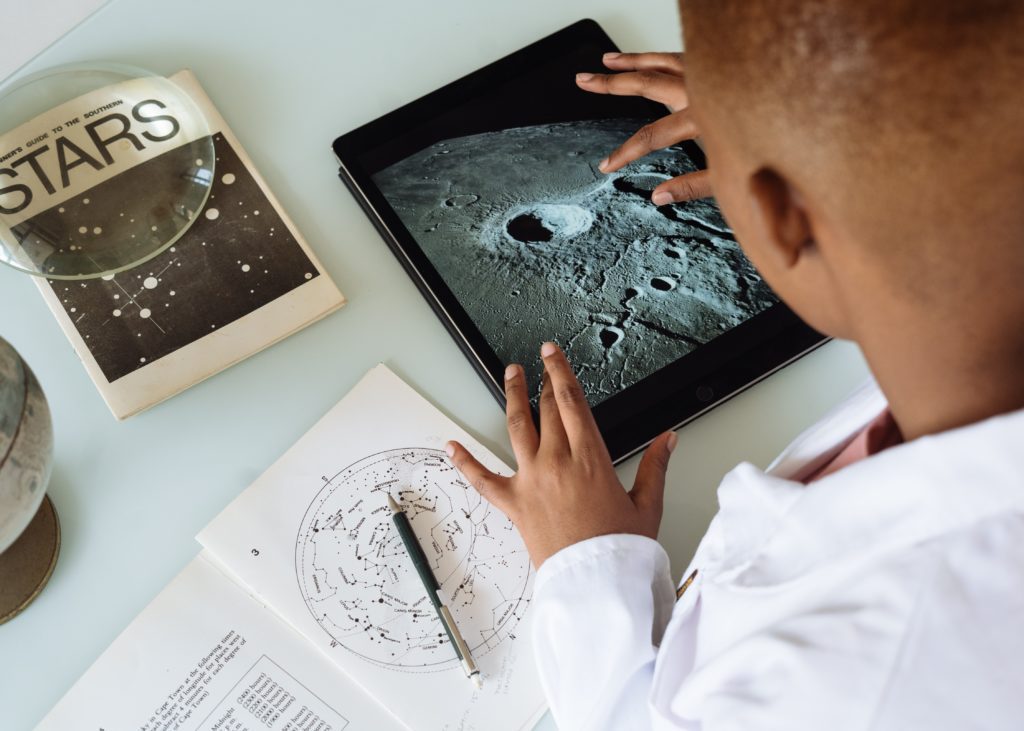 self-learner using ipad, book and notebook on desk for self-learning