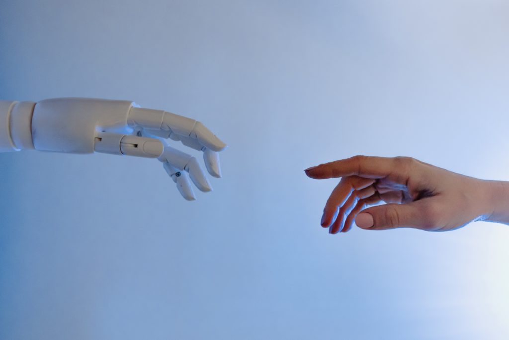 robot and human hand reaching out to highlight ai in education