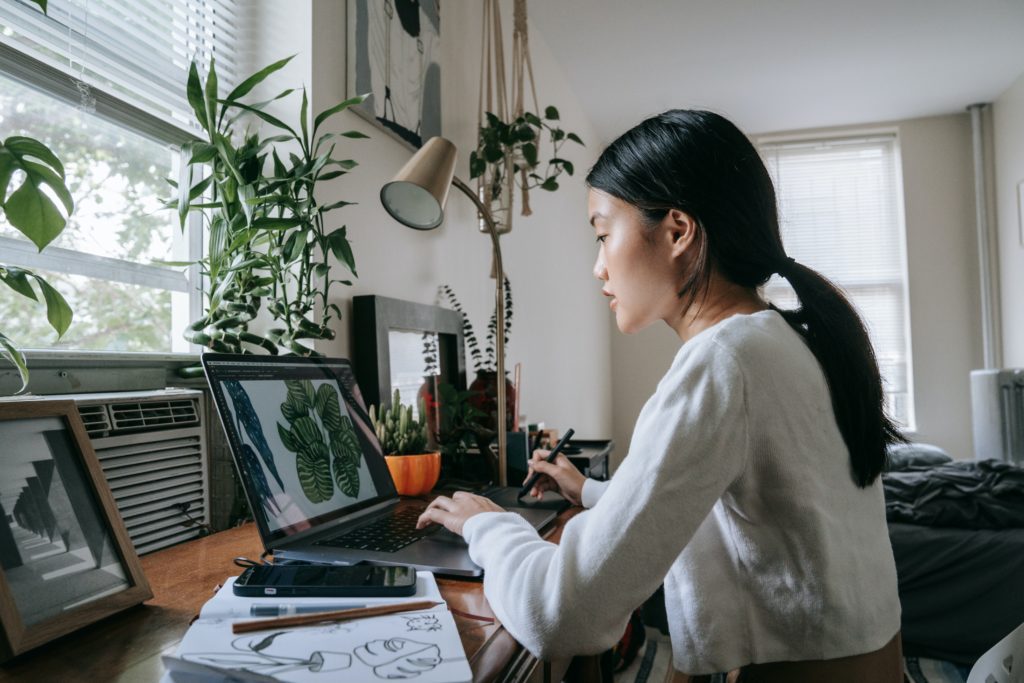 female student with adhd sat at desk with laptop and notebook