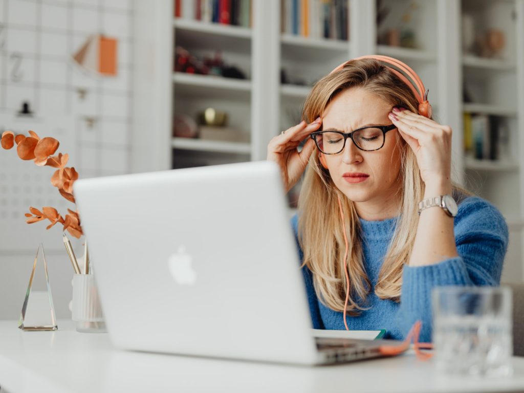 student sitting and looking at her laptop looking stressed out